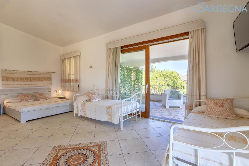 une chambre avec deux lits et un balcon dans l'établissement Villa Janas Luxury Villa surrounded by large park, swimming pool, parking and Wifi, à Alghero