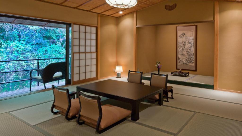 une salle à manger avec une table et des chaises et une fenêtre dans l'établissement Tofuya Resort&Spa-Izu, à Izu