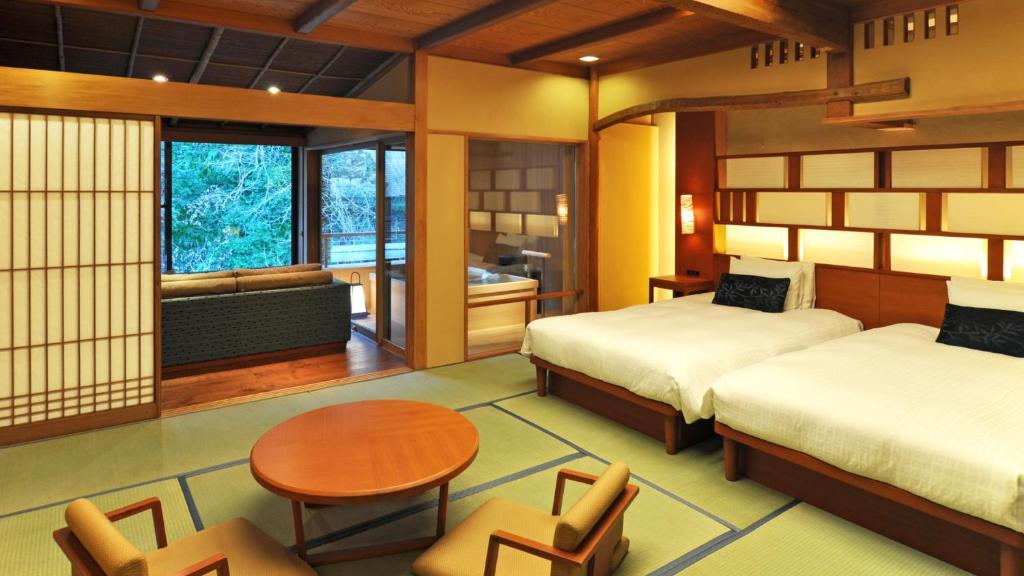 une chambre avec deux lits et une table et des chaises dans l'établissement Tofuya Resort&Spa-Izu, à Izu