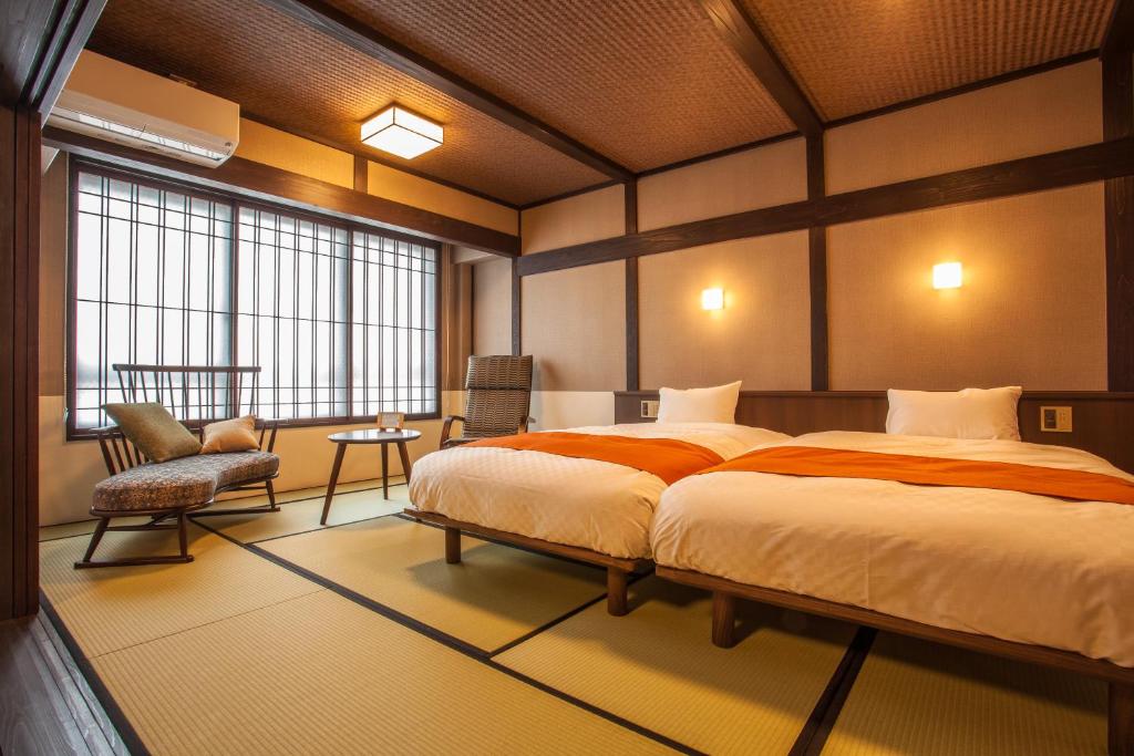 une chambre avec un grand lit et une chaise dans l'établissement Ryokan Asunaro, à Takayama 37 autres photos