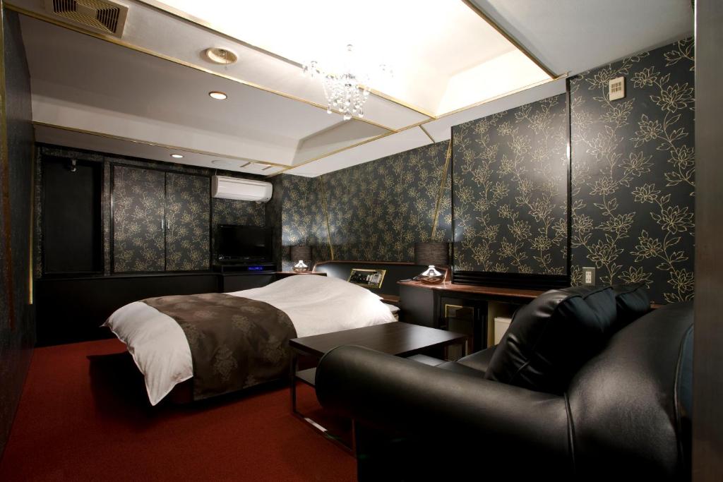 une chambre avec un lit et un canapé dans l'établissement Hotel Jay -Adult Only-, à Osaka