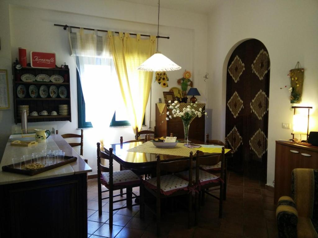 une cuisine et une salle à manger avec une table et des chaises dans l'établissement Mamma Arancia, à Pedagaggi