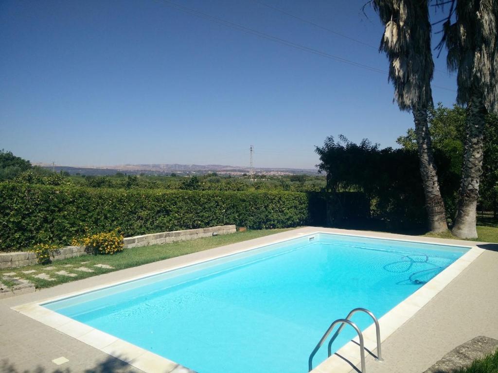 une grande piscine bleue dans une cour dans l'établissement Mamma Arancia, à Pedagaggi