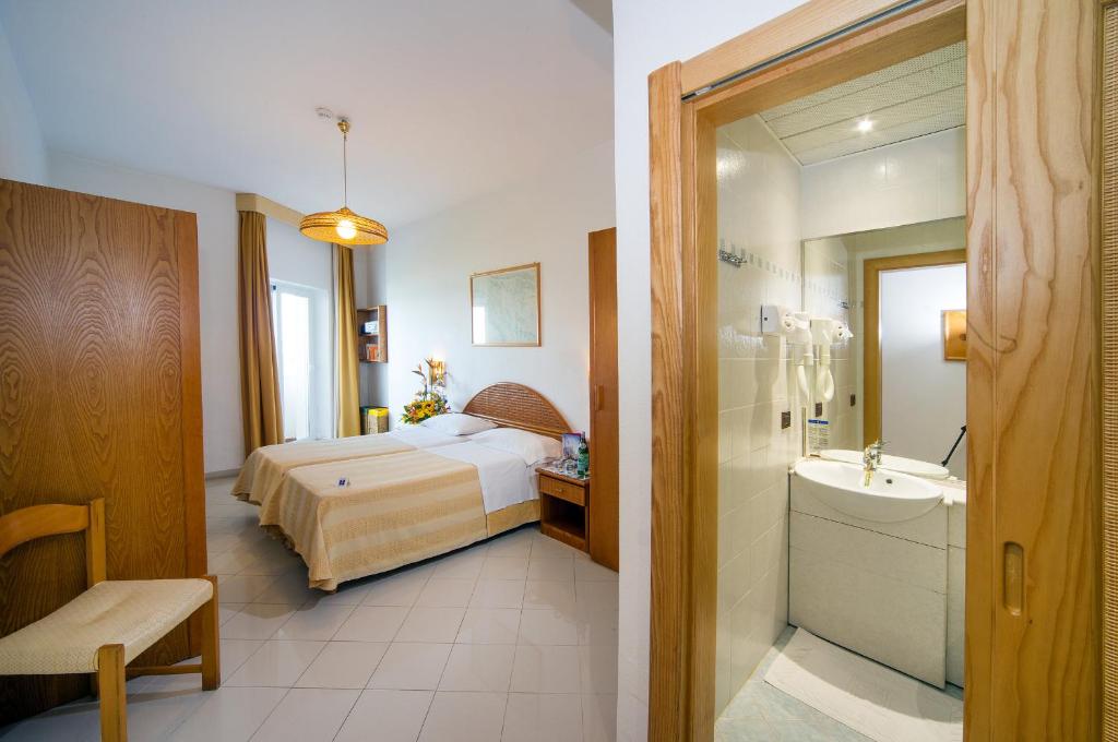une chambre d'hôtel avec un lit et une salle de bain dans l'établissement Ecoresort Le Sirene - Caroli Hotels, à Gallipoli