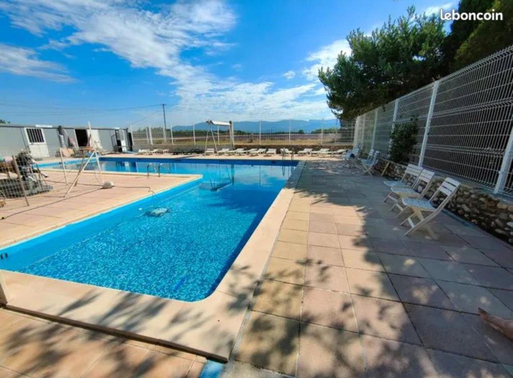une grande piscine avec des chaises dans l'établissement Mobil home, à Sainte-Croix-de-Verdon
