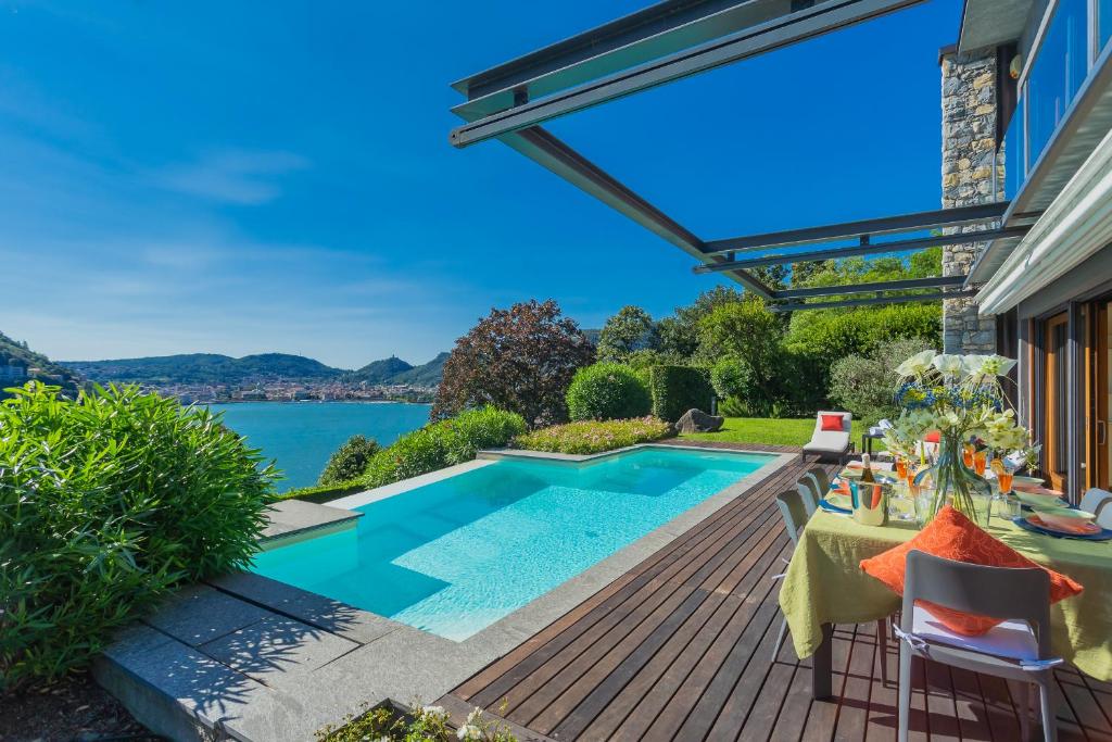 une cour avec une piscine, une table et des chaises dans l'établissement Villa Infinity Lake Como by Rent All Como, à Côme