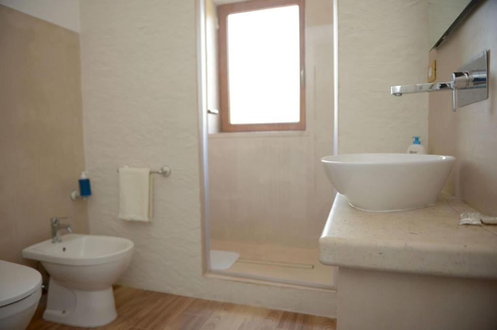 une salle de bain avec un lavabo, des toilettes et une douche dans l'établissement Masseria le Colonne del Sole, à Ostuni 25 autres photos