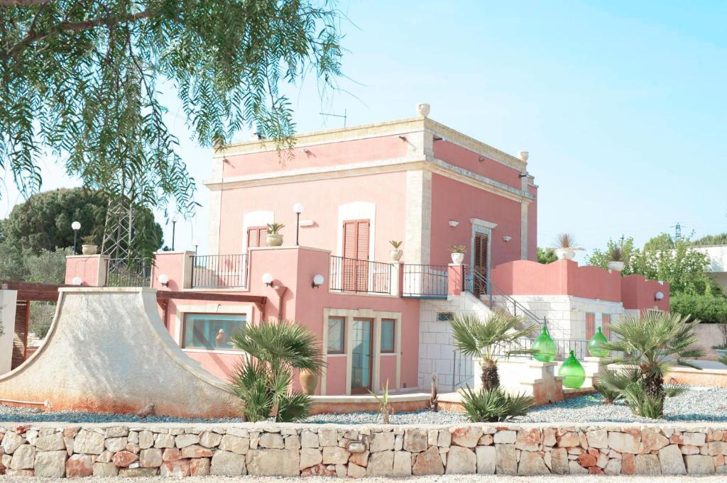 une maison rose avec un skateboard devant elle dans l'établissement Masseria le Colonne del Sole, à Ostuni