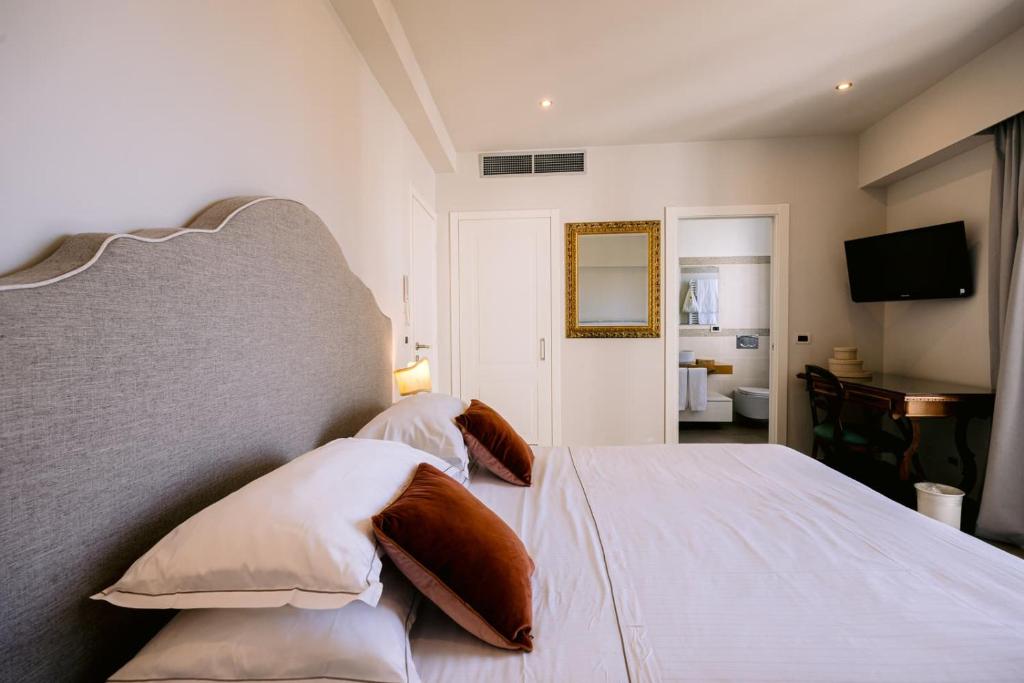 une chambre avec un grand lit blanc avec des oreillers dans l'établissement Hotel Villa Paradiso, à Taormine