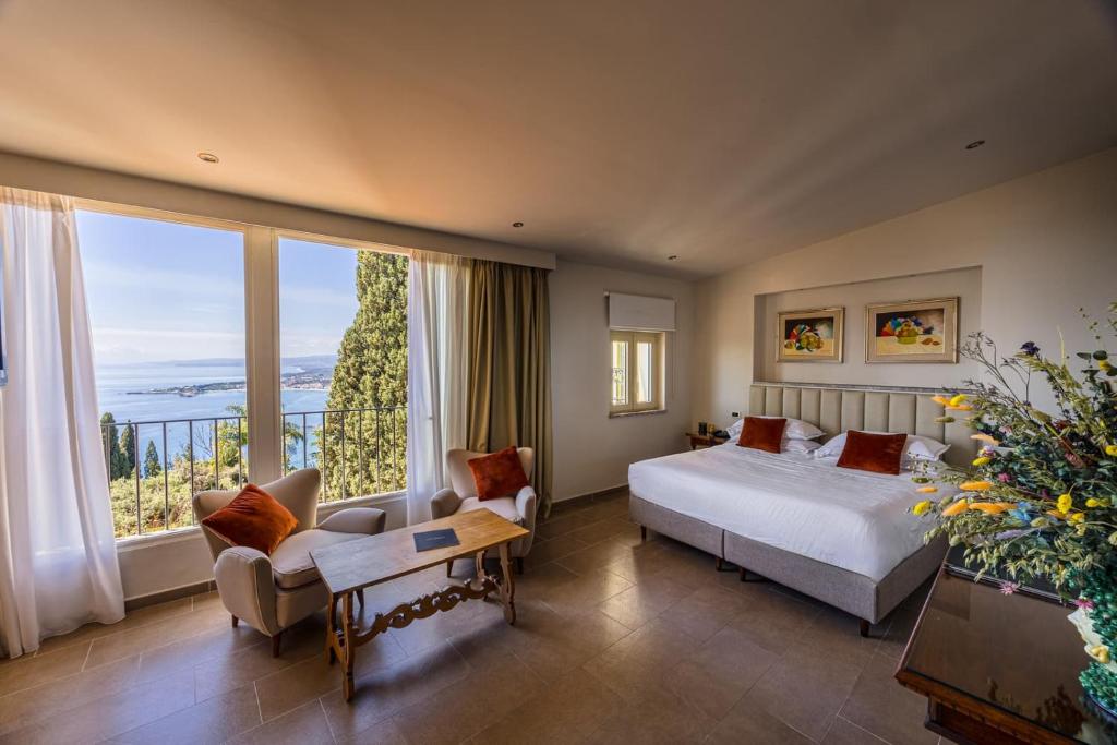 une chambre avec un lit et une grande fenêtre dans l'établissement Hotel Villa Paradiso, à Taormine