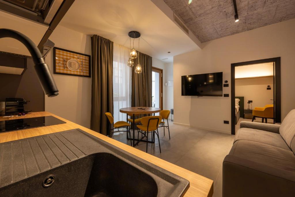 Il dispose d'une cuisine et d'un salon avec un évier et un canapé. dans l'établissement Meg Lifestyle Hotel & Apartaments, à Riccione