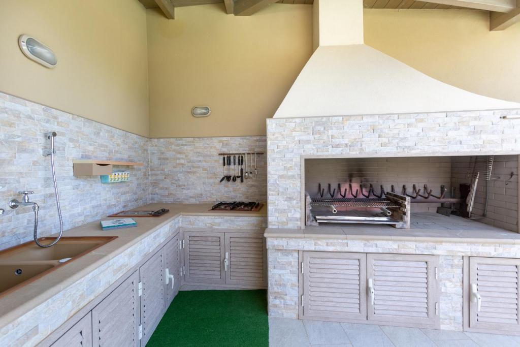 - une cuisine avec une cheminée et un évier dans l'établissement Villa Rachele 2 private pools, à Porto Pino