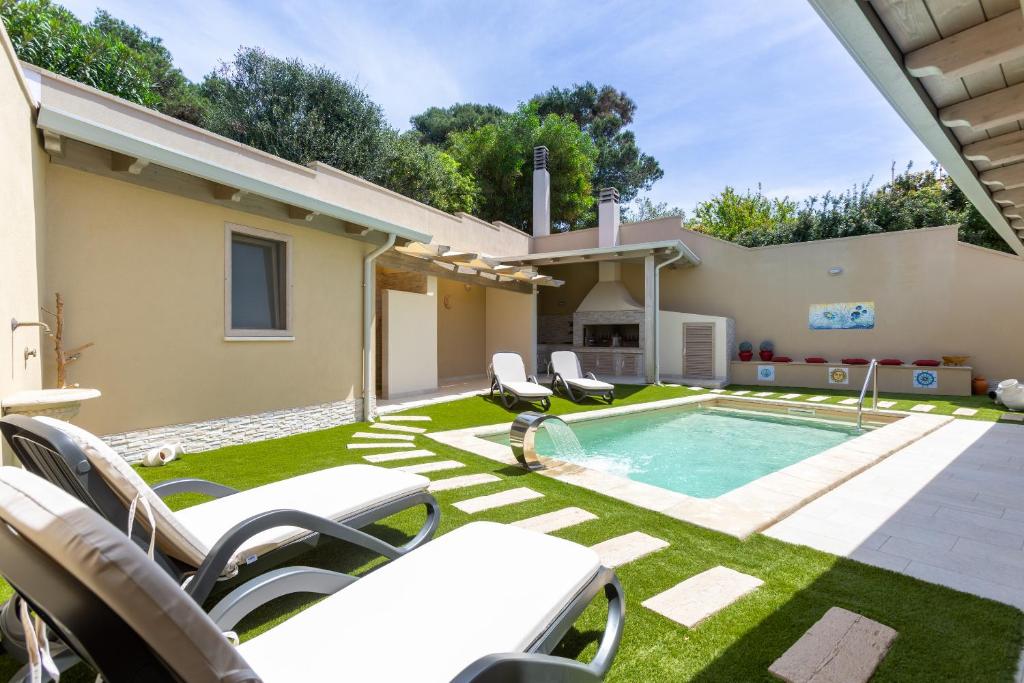 une arrière-cour avec une piscine, des chaises et une maison dans l'établissement Villa Rachele 2 private pools, à Porto Pino