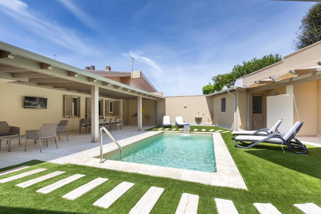 une cour avec une piscine et de l'herbe verte dans l'établissement Villa Rachele 2 private pools, à Porto Pino
