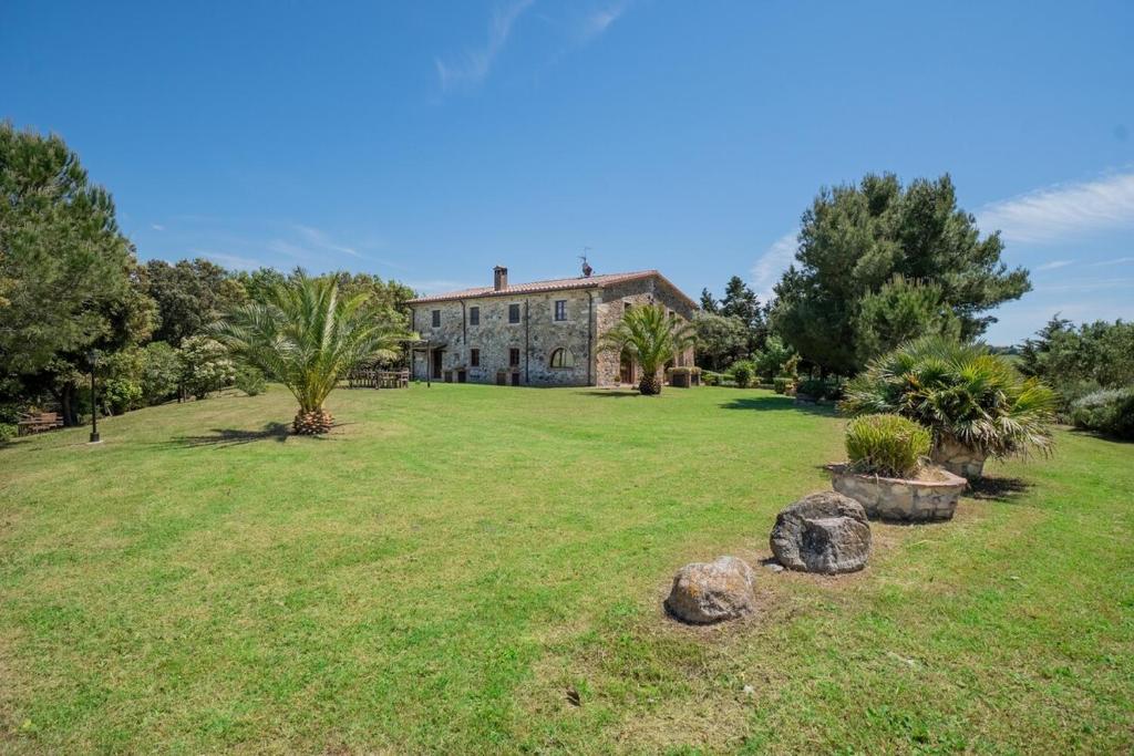 une grande maison avec une cour avec des arbres et des rochers dans l'établissement Villa La Lespa W-Pool Biliardo and Lake View, à Casa SantʼAndrea