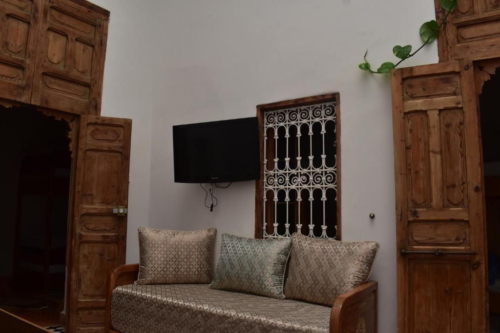 un salon avec un canapé et une télévision à écran plat dans l'établissement Hostel Capital, à Rabat