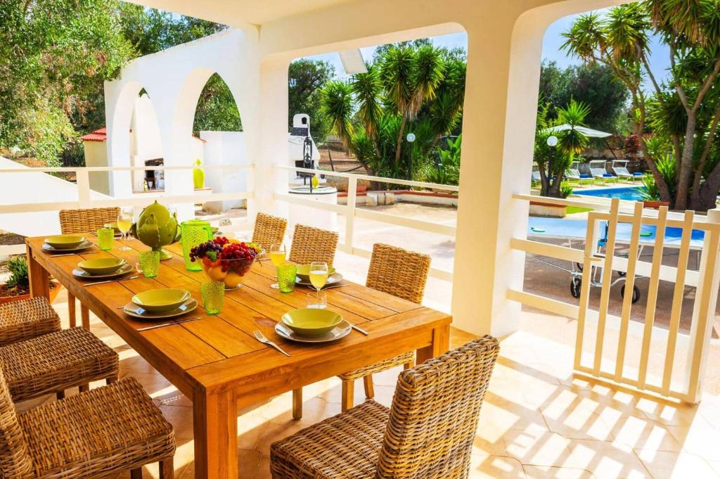 une salle à manger avec une table et des chaises en bois dans l'établissement Villa Olivier by Villa Plus, à Carovigno