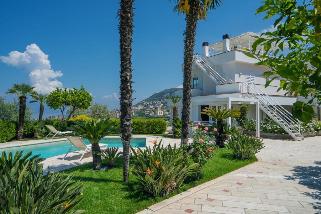 une villa avec piscine et palmiers dans l'établissement Villagraziosa, à Vico Equense