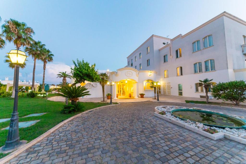 un bâtiment avec un lampadaire devant lui dans l'établissement Nicolaus Prime Il Gabbiano Hotel, à Pulsano