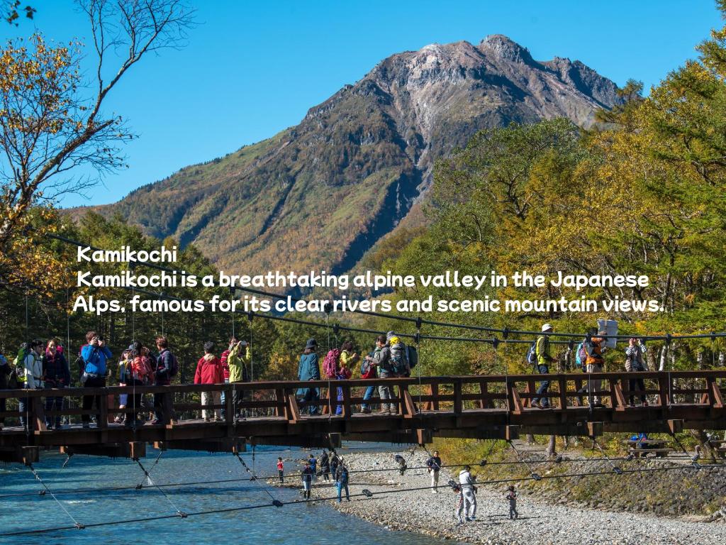 un pont sur une rivière avec une montagne en arrière-plan dans l'établissement Oiwakeya Ryokan, à Matsumoto