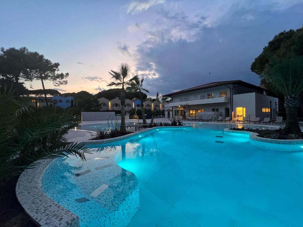 - une piscine avec éclairage bleu en face d'un bâtiment dans l'établissement Dune Dependance, à Bibione 23 autres photos