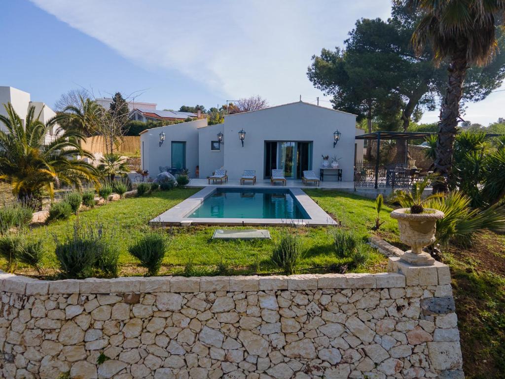 une maison avec une piscine dans une cour dans l'établissement Villa Malena con piscina privata, à Noto