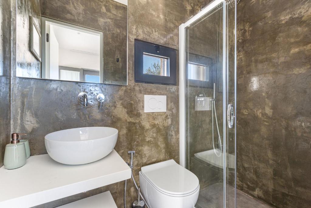 une salle de bain avec un lavabo, des toilettes et une douche dans l'établissement Villa Libe by Perle di Puglia, à Specchiolla