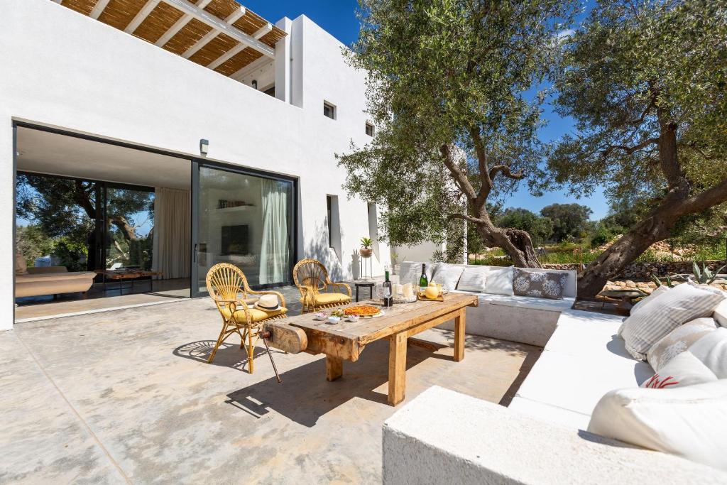 un patio avec une table et des chaises en bois dans l'établissement Villa Libe by Perle di Puglia, à Specchiolla