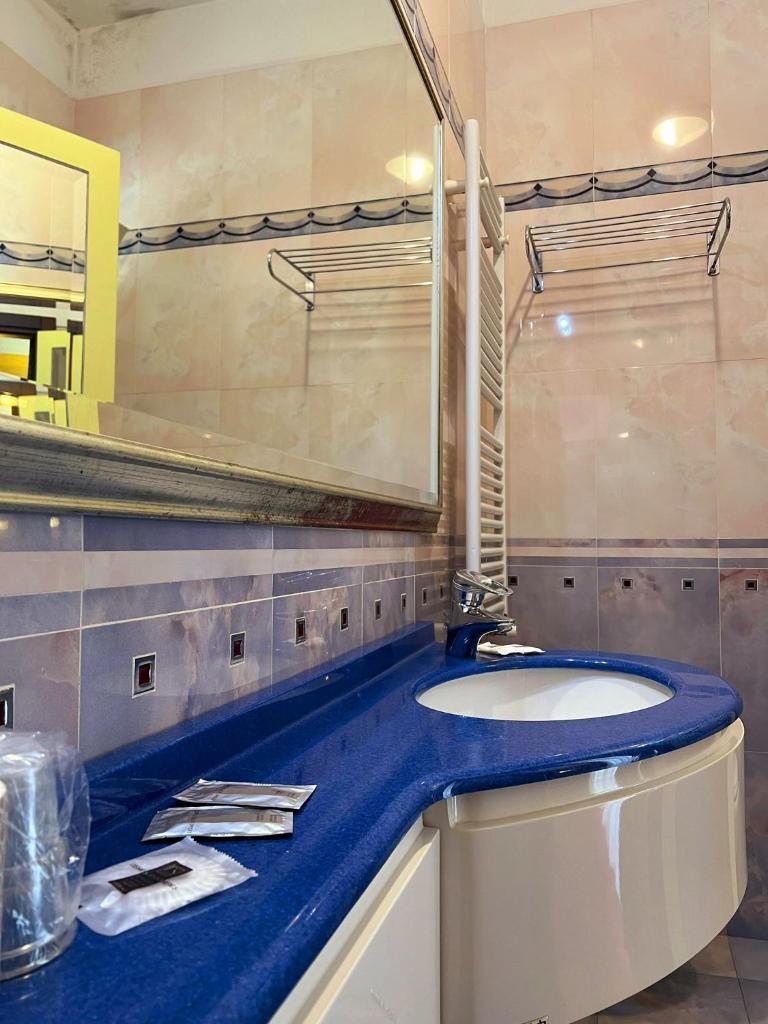 une salle de bain avec un lavabo et un miroir dans l'établissement Hotel Soleblu, à Rimini