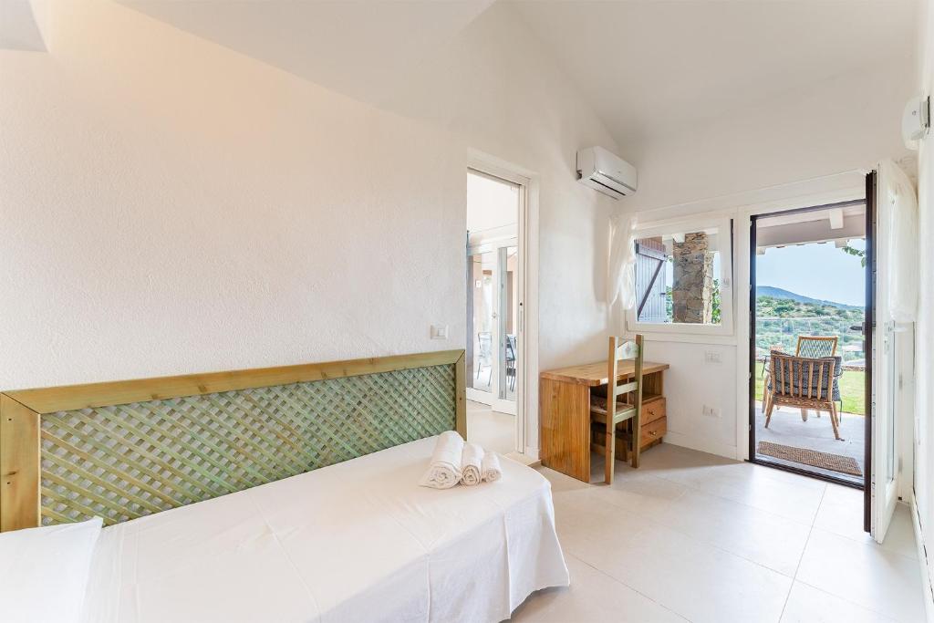 une chambre avec un lit, un bureau et une fenêtre dans l'établissement Lux Villa Palma, Chia, à Chia