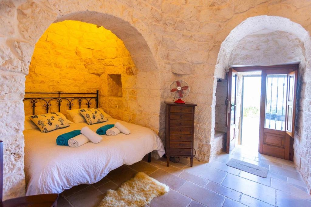 une chambre avec un lit dans un mur de pierre dans l'établissement Villa Trullo Selva Piccolo by Villa Plus, à Martina Franca