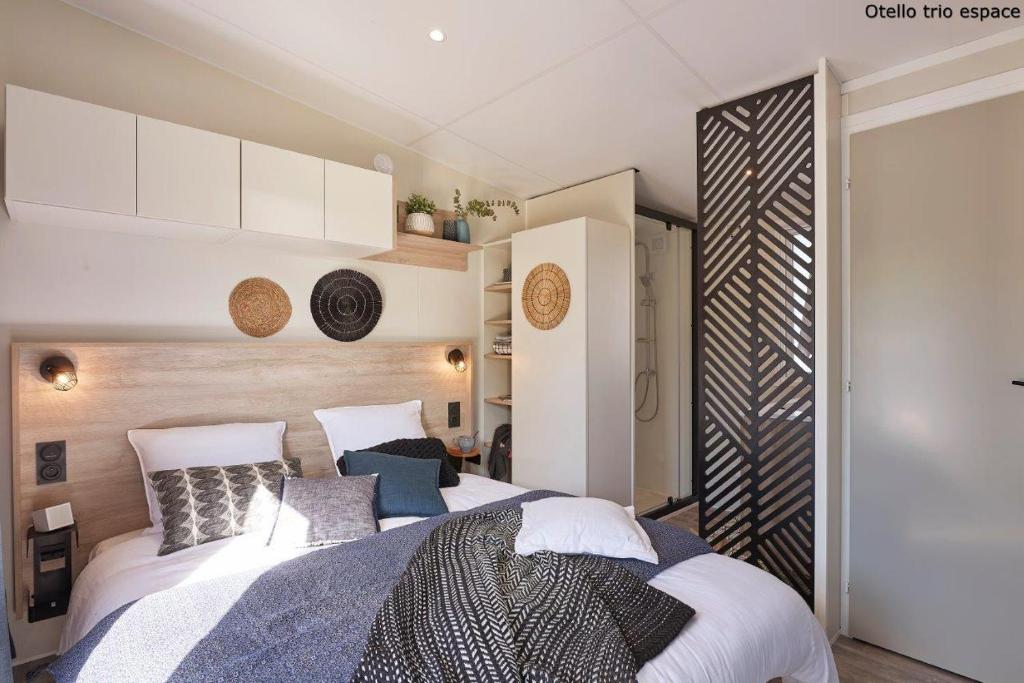 une chambre avec un grand lit avec des oreillers dans l'établissement Mobile Evasion okpl SEGUR, à Saint-Raphaël