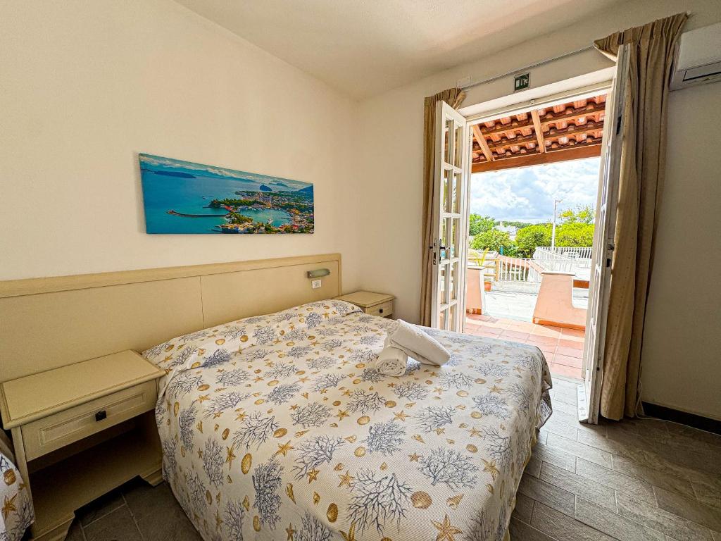 - une chambre avec un lit et une porte donnant sur une terrasse dans l'établissement Av Club Terme Colella, à Ischia