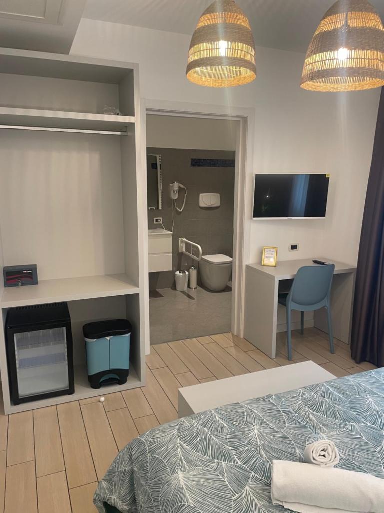 une chambre d'hôtel avec un lit et un bureau et une chambre avec un lit gmaxwell dans l'établissement Hotel La Pergola di Venezia, sur le Lido de Venise