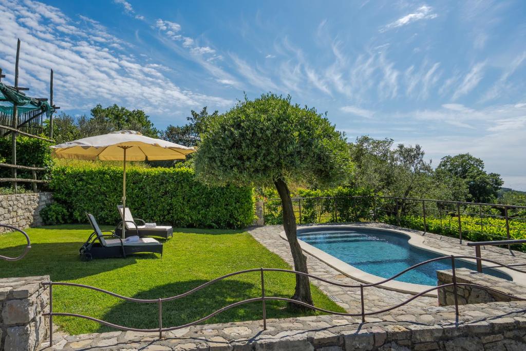 une piscine dans une cour avec un parasol dans l'établissement Villa Mimì between Sorrento and Positano, à Massa Lubrense
