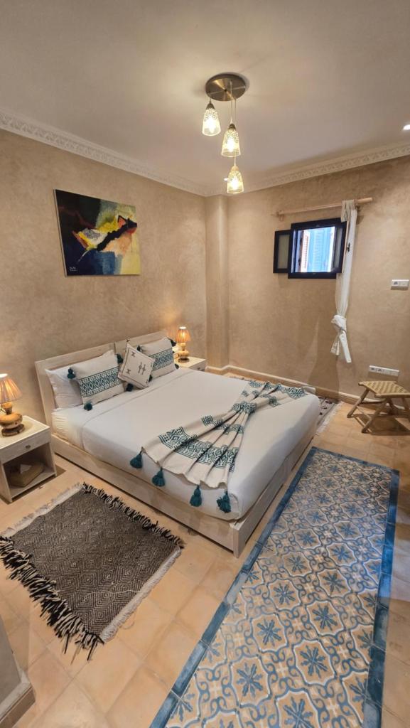 une chambre avec un grand lit avec un tapis dans l'établissement Riad YAHIA ZAMANE, à Essaouira