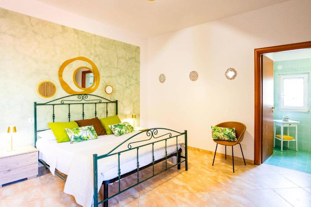 une chambre avec un lit et une chaise dans l'établissement Villa Maria Rosaria by Villa Plus, à Ceglie Messapica