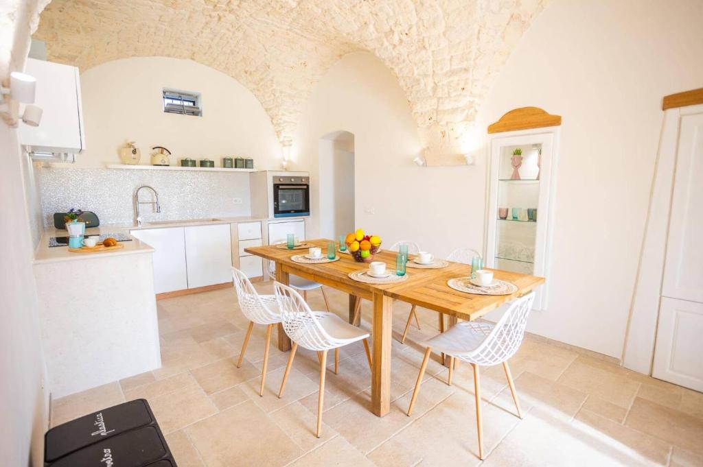 une cuisine avec une table et des chaises en bois dans l'établissement Villa Angelita by Villa Plus, à Ceglie Messapica
