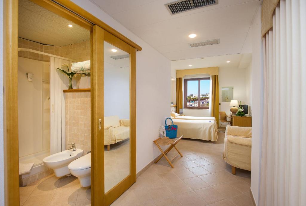 une salle de bain avec toilettes et lavabo dans une chambre dans l'établissement Hotel Terminal - Caroli Hotels, à Leuca