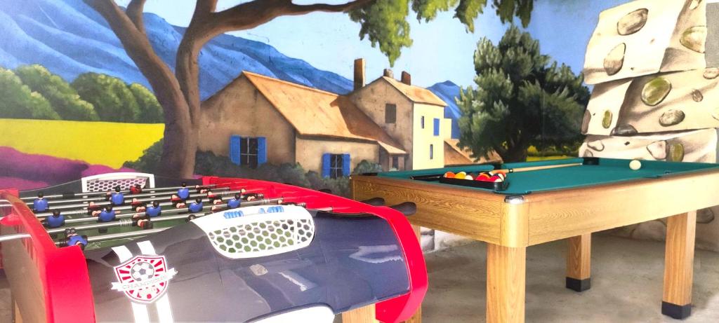 une chambre avec une table et un billard dans l'établissement Villa Spacieuse au Calme Absolu avec Grande Piscine Jacuzzi Chauffé - Grand Jardin Sans Vis a vis- Salle de Jeux avec Fresque du Nougat - Ideal Familles et Groupes Drome Provencale, à Montélimar