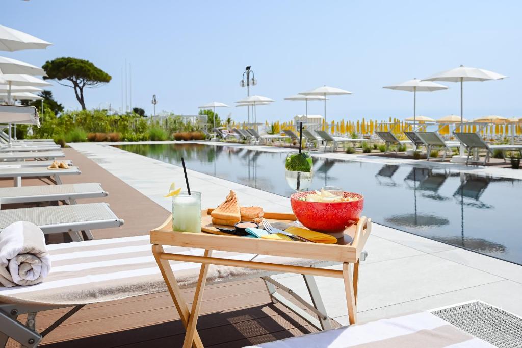 - un plateau de nourriture sur une table à côté de la piscine dans l'établissement Hotel Las Vegas, à Lido di Jesolo