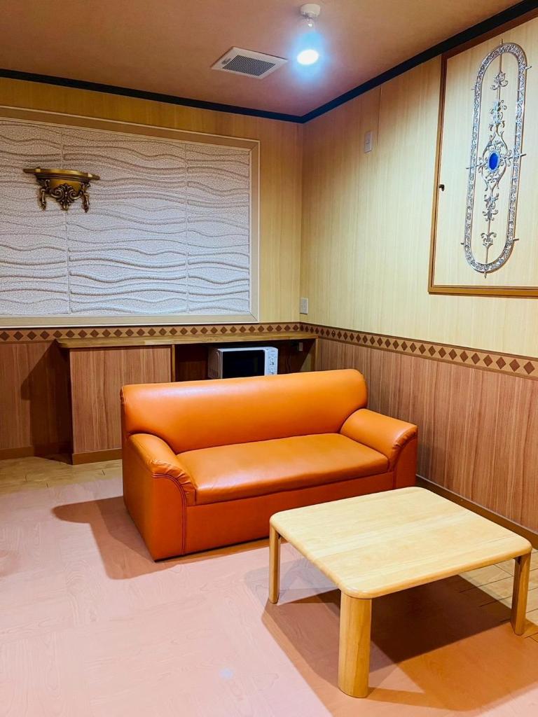 un salon avec un canapé et une table basse dans l'établissement ホテル リトリート Hotel retreat, à Sado