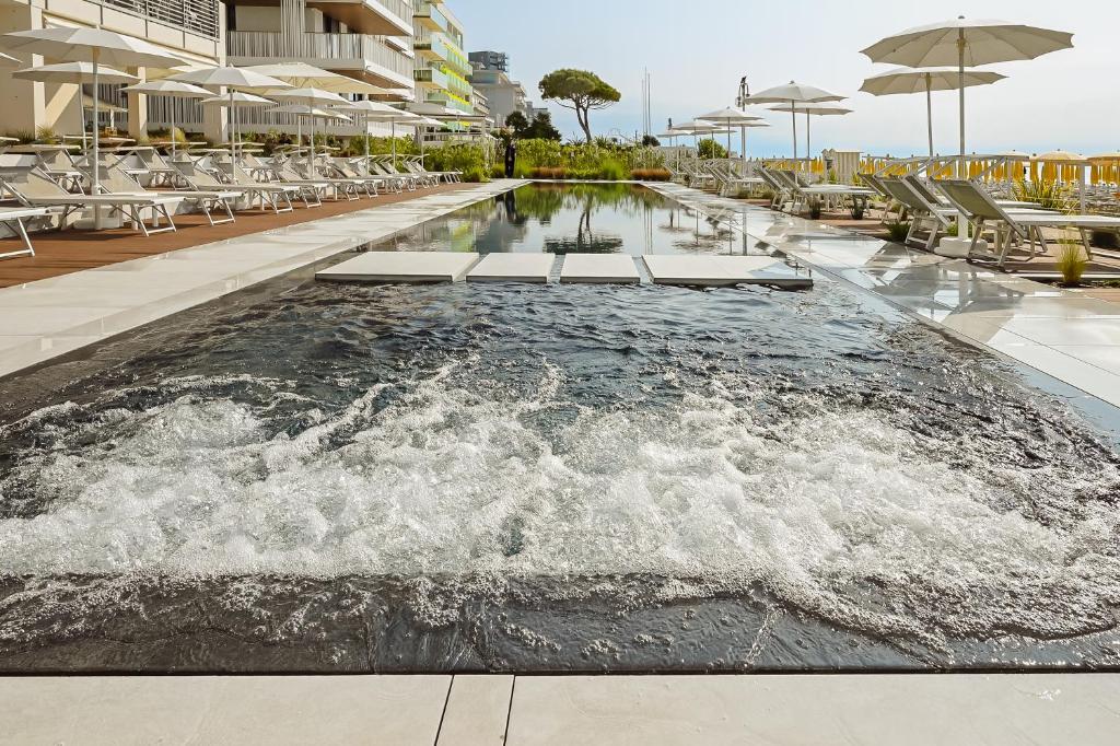 une piscine dans un complexe hôtelier avec des chaises et un débordement dans l'établissement Hotel Las Vegas, à Lido di Jesolo