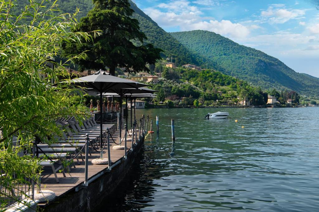 - un quai avec des chaises et des parasols à côté d'un lac dans l'établissement Hotel Rivalago, à Sulzano 265 autres photos