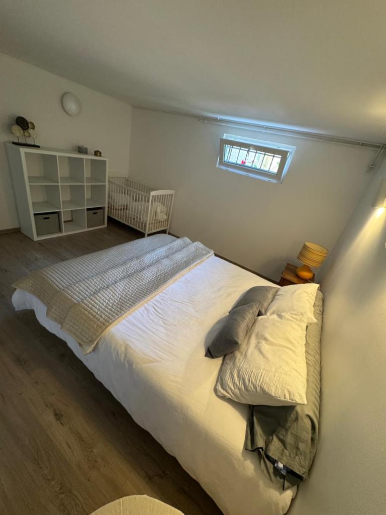 une chambre avec un grand lit blanc avec une fenêtre dans l'établissement Gites de Frans, à Frans