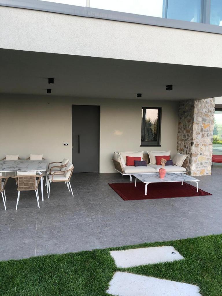 un patio avec deux canapés, une table et des chaises dans l'établissement Villa La Biancolilla, à Marciaga