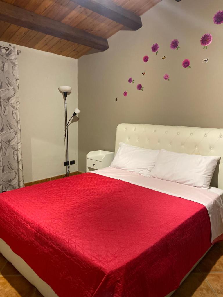 une chambre avec un lit avec une couverture rouge dans l'établissement Villa Marylove - Scicli 200m dal mare, à Cava dʼAliga