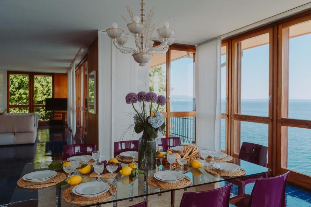 une salle à manger avec une table avec un vase de fleurs dans l'établissement Holiday Garda Villa Dolcelago Lake Front, à Moniga del Garda