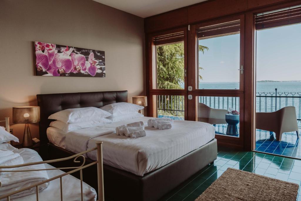 une chambre avec un lit et un balcon dans l'établissement Holiday Garda Villa Dolcelago Lake Front, à Moniga del Garda