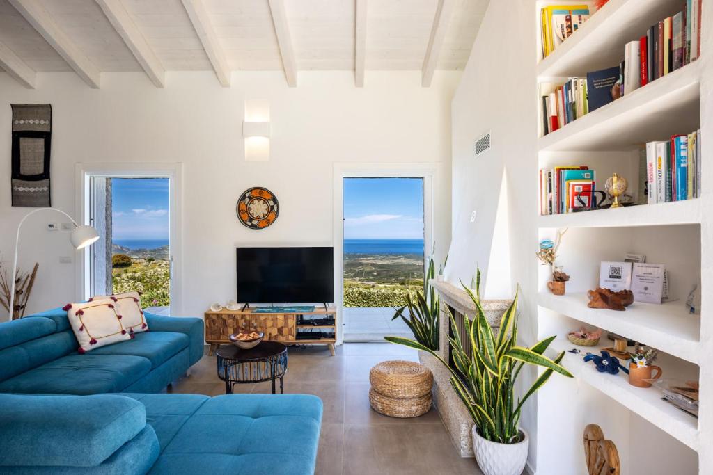 un salon avec un canapé bleu et une télévision dans l'établissement Sardegna è - Stazzu di l'Incantu con piscina, à Aglientu